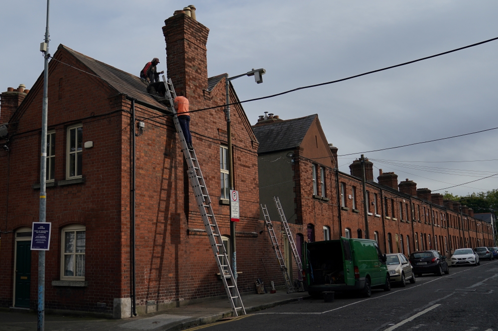 Workers make repairs to the roof of a residential terraced house, amid the coronavirus disease (COVID-19) outbreak, in Dublin, Ireland October 1, 2020. (REUTERS/Clodagh Kilcoyne)