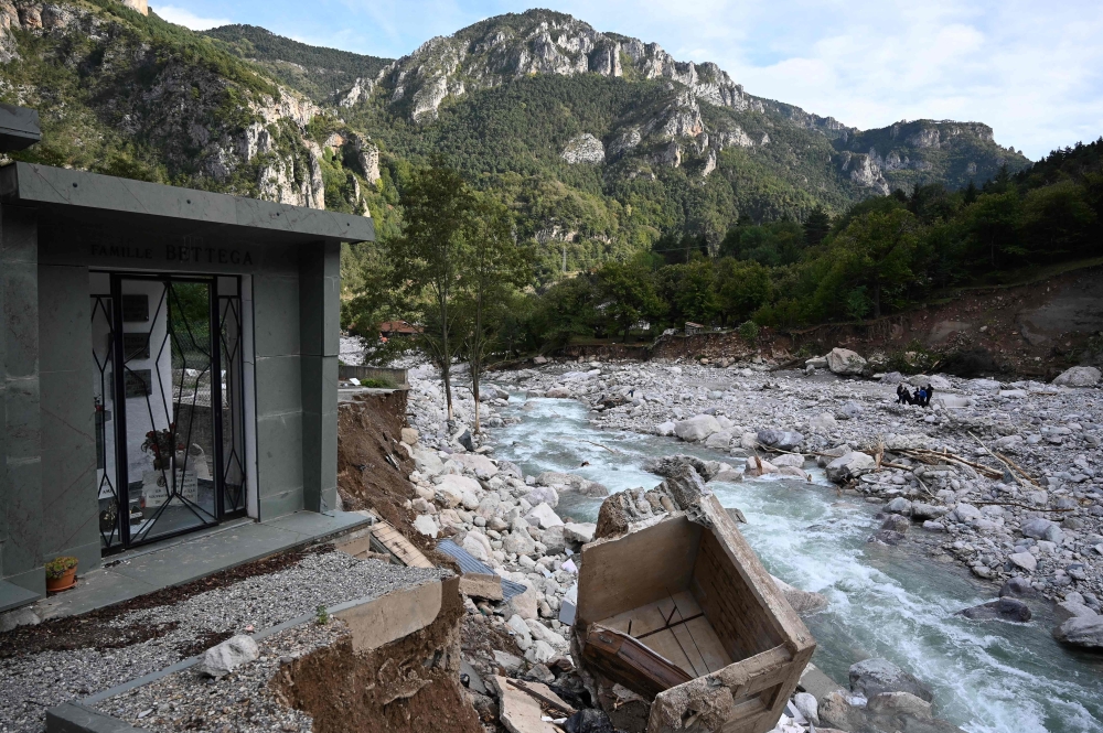A picture shows sepulchres and a coffin in the partially washed away cemetery of Saint-Dalmas-de-Tende in south-east France, near the Italian border, on October 6, 2020  AFP / Fabien NOVIAL
