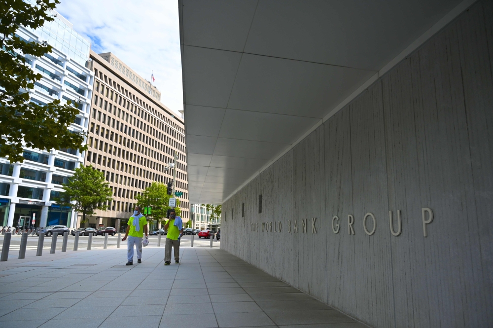 Two workers are seen on empty pavement next to the World Bank headquarters at lunchtime in Washington, DC on October 1, 2020.  AFP / Eric BARADAT
