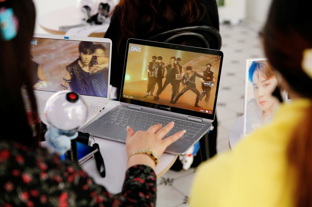 Fans of K-pop idol boy band BTS watch a live streaming online concert, wearing protective masks to avoid the spread of the coronavirus disease (COVID-19), at a cafe in Seoul, South Korea October 10, 2020. REUTERS/Heo Ran