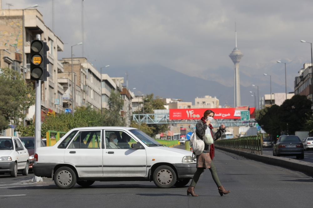 An Iranian woman wearing a face mask crosses a street after Iranian authorities made it mandatory for all to wear face masks in public following the outbreak of the coronavirus disease (COVID19), in Tehran Iran October 10, 2020. Majid Asgaripour/WANA  
