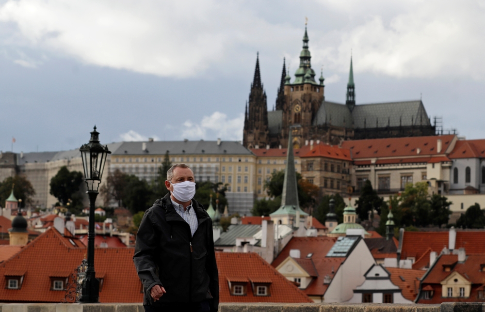 A man wearing a face mask walks across the medieval Charles Bridge as the spread of the coronavirus disease (COVID-19) continues in Prague, Czech Republic, October 7, 2020. Reuters/David W Cerny