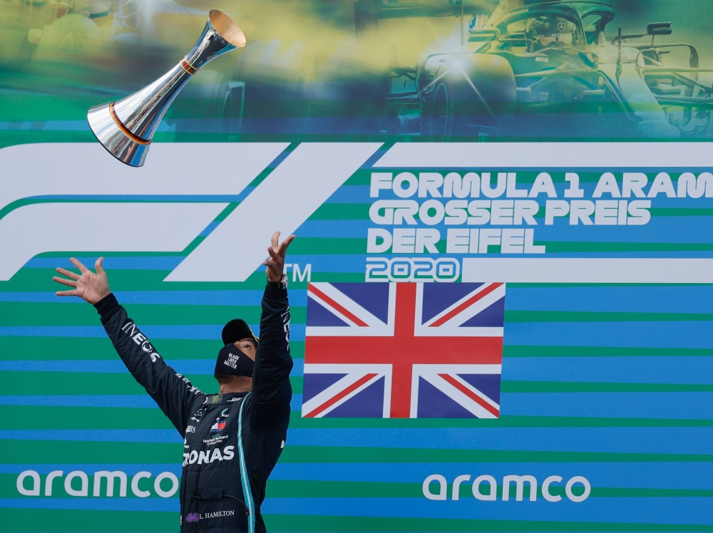 Winner Mercedes' British driver Lewis Hamilton celebrates with his trophy on the podium after the German Formula One Eifel Grand Prix at the Nuerburgring circuit in Nuerburg, western Germany, on October 11, 2020. (AFP / POOL / RONALD WITTEK)