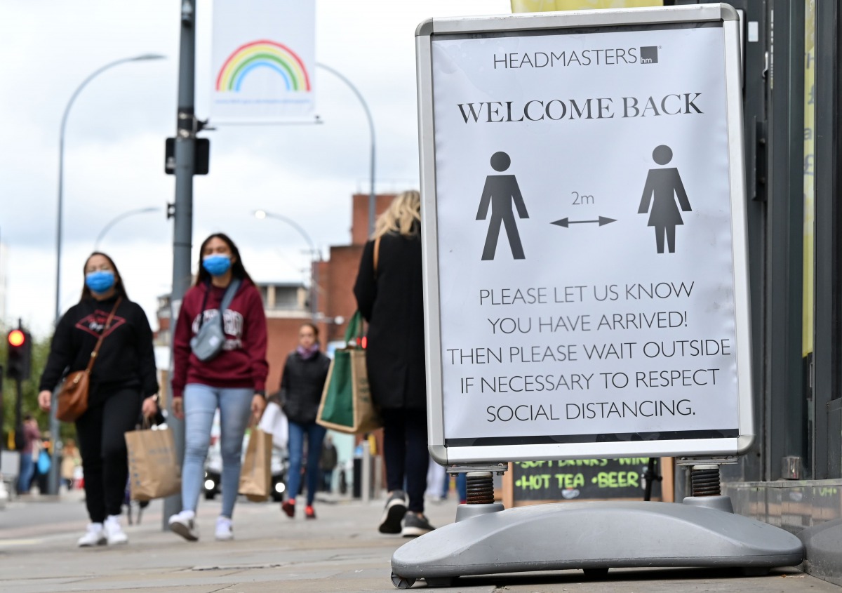 Pedestrians and shoppers, some wearing face masks as a precaution against the transmission of the novel coronavirus, walk in the high street in west London on October 11, 2020. / AFP / JUSTIN TALLIS