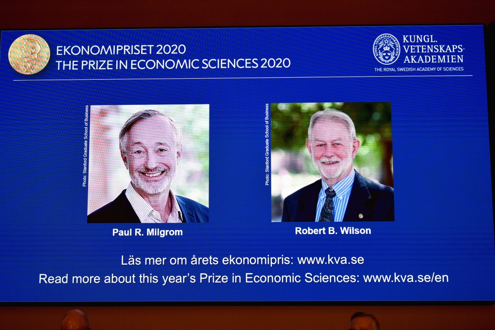 Pictures of the winners of the 2020 Nobel prize in economic sciences, Paul R. Milgrom and Robert B. Wilson, are displayed on a screen at a news conference in Stockholm, Sweden October 12, 2020. TT News Agency/Anders Wiklund via REUTERS