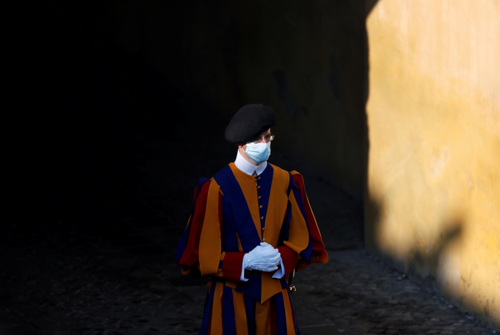 FILE PHOTO: A Swiss guard wearing a protective face mask is seen at the San Damaso courtyard ahead of the weekly general audience at the Vatican, September 16, 2020. REUTERS/Yara Nardi/File Photo