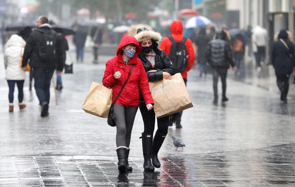 Women wearing face masks carry shopping bags amid the outbreak of the coronavirus disease (COVID-19) in Liverpool, Britain, October 12, 2020. Reuters/Phil Noble
