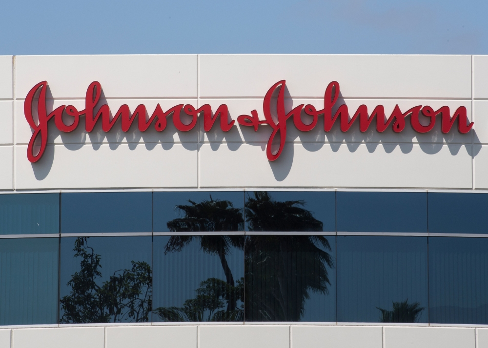 In this file photo taken on August 28, 2019 a sign on a building at the Johnson & Johnson campus shows their logo in Irvine, California. Johnson & Johnson said October 12, 2020, it had temporarily halted its Covid-19 vaccine trial because one of its parti