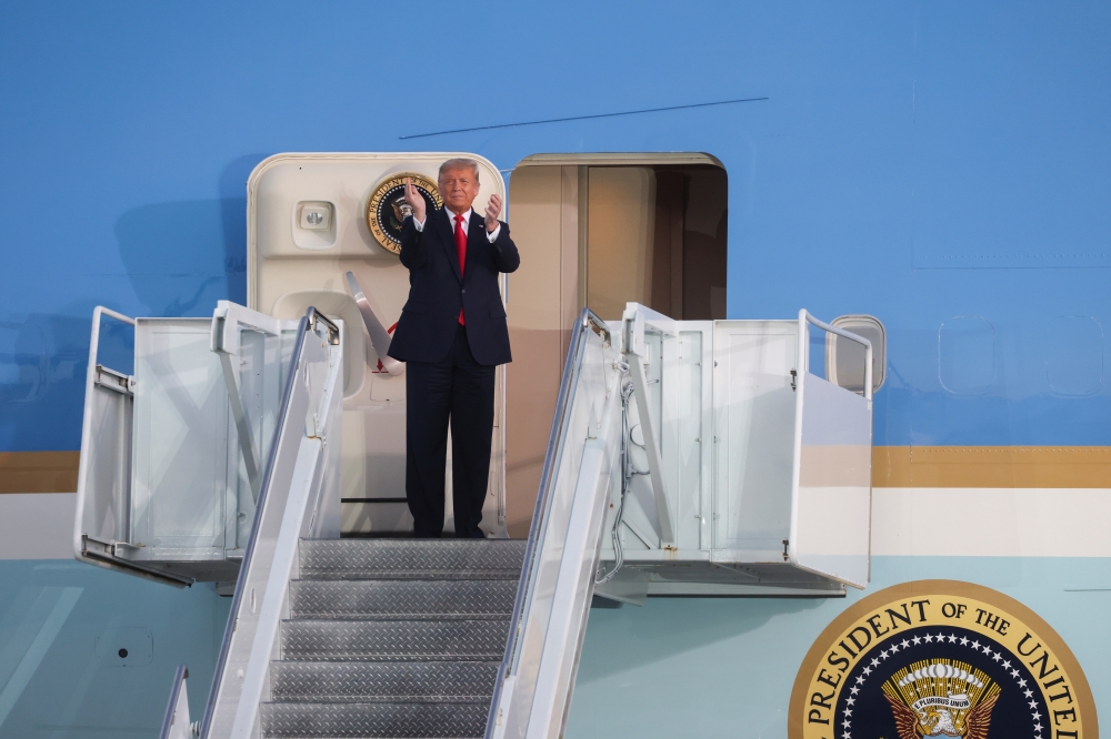 US President Donald Trump applauds as he disembarks from Air Force One for a campaign rally, his first since being treated for the coronavirus disease (COVID-19), at Orlando Sanford International Airport in Sanford, Florida, U.S., October 12, 2020. REUTER