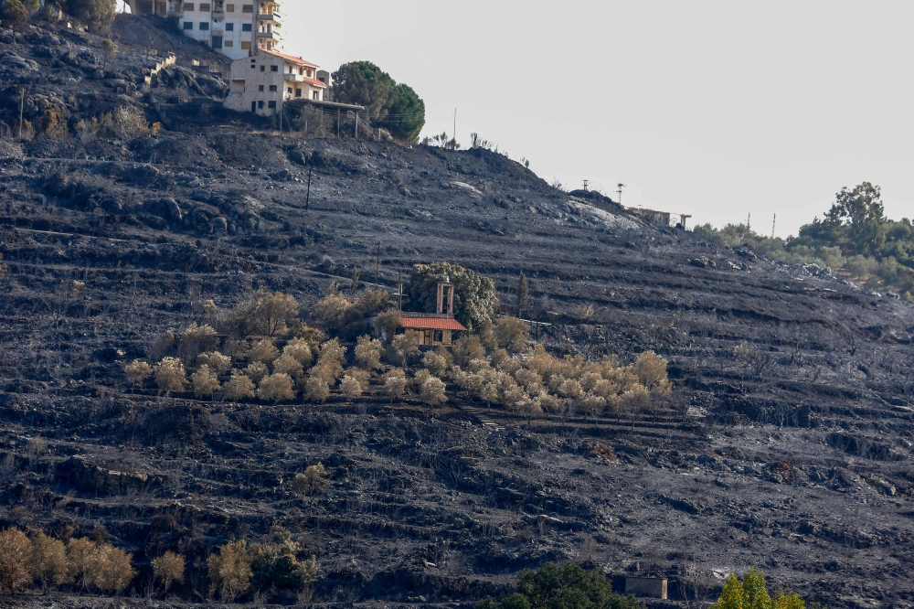A picture taken on October 11, 2020, shows a church in the middle of a scorched hillside due to forest fires in the countryside of the Syrian western city of Tartus.  AFP / LOUAI BESHARA