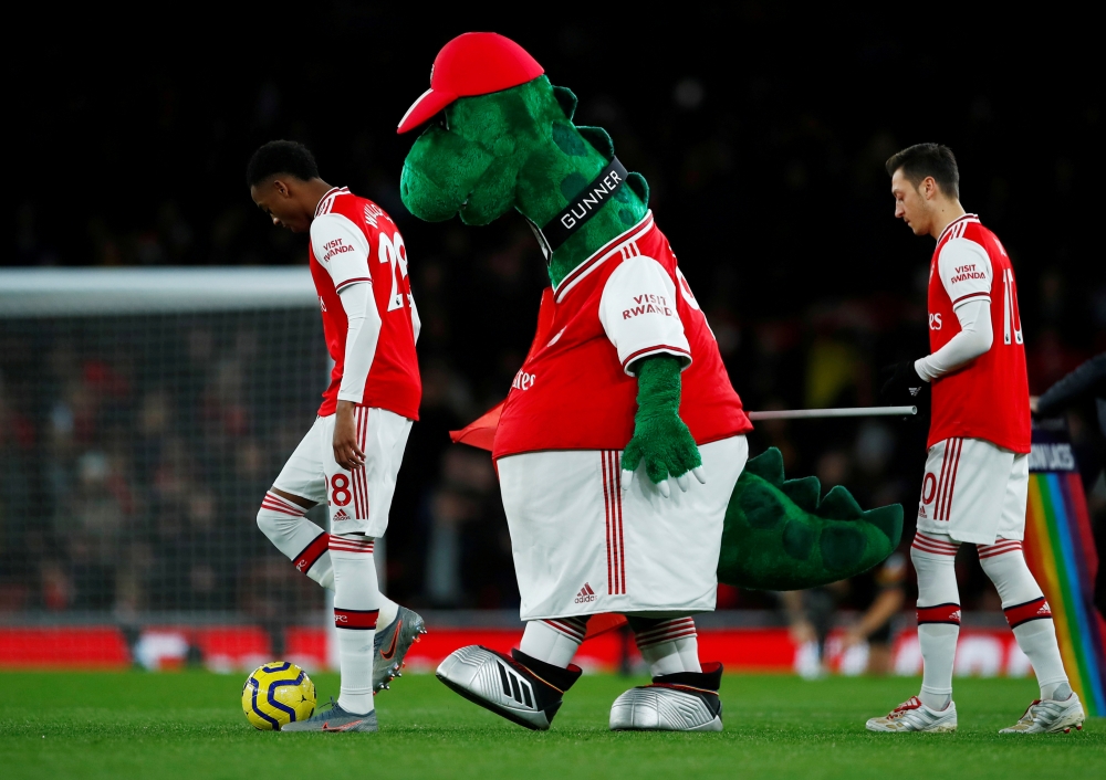 Arsenal's Joe Willock and Arsenal's Mesut Ozil with the mascot before the match REUTERS/Eddie Keogh 