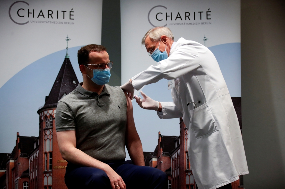 German Health Minister Jens Spahn receives an influenza injection from doctor Harald Bias at Charite hospital, during the spread of the coronavirus disease (COVID-19), in Berlin, Germany, October 14, 2020. REUTERS/Hannibal Hanschke/Pool