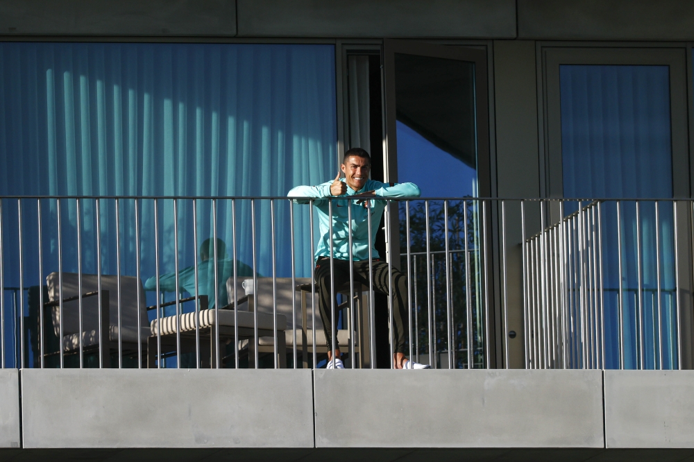 Portugal´s forward Cristiano Ronaldo giving the thumb up as he watches his teammates training session from a balcony at Portugal´s training camp in Oeiras, on the outskirts of Lisbon on October 13, 2020.  AFP / Portuguese Football Federation (FPF)
