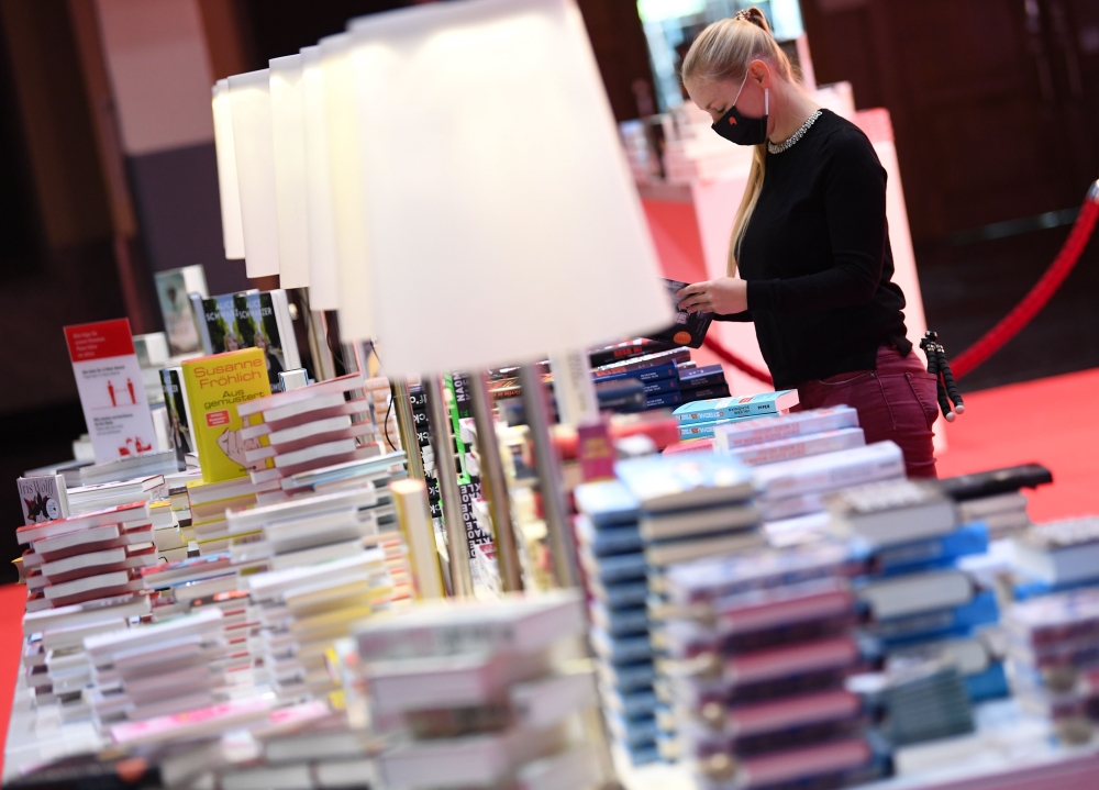 An employe of the Frankfurt Book fair works on book shelves prior the opening press conference of the 2020 Frankfurt Book fair on October 13, 2020.  AFP / POOL / Arne Dedert
