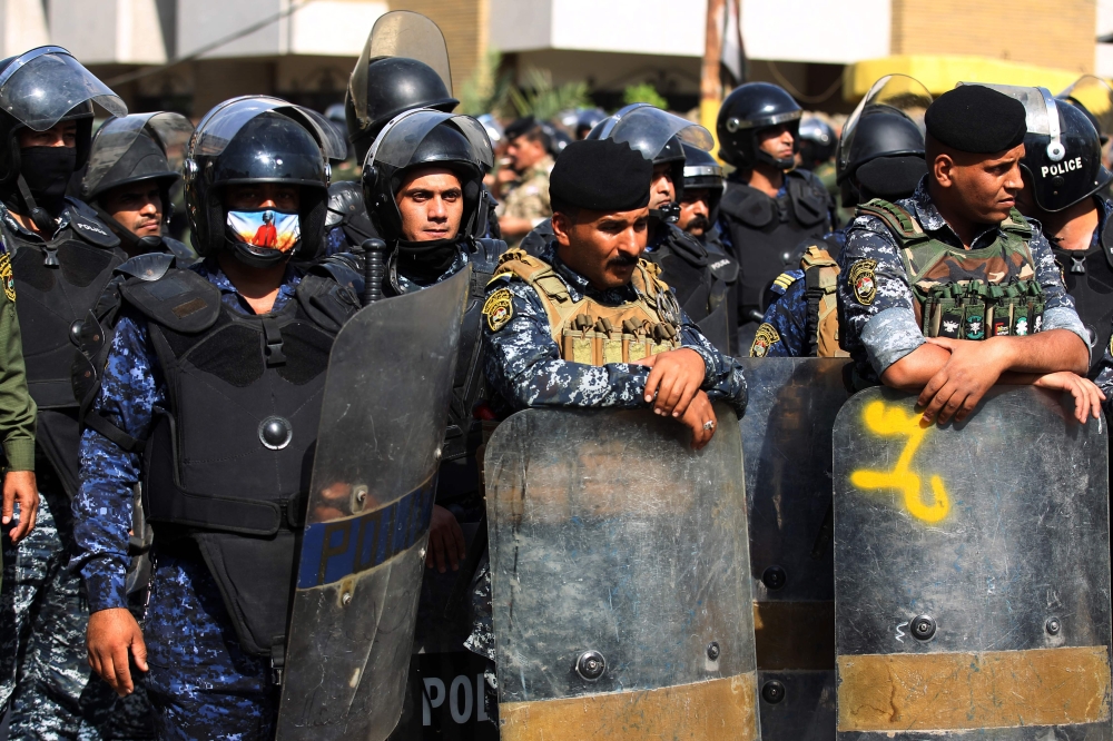 Members of the Iraqi security forces stand guard as demonstrators, supporters of the Hashed al Shaabi, ransack the Kurdish Democratic Party's headquarters in the capital Baghdad on October 17, 2020. AFP / AHMAD AL-RUBAYE