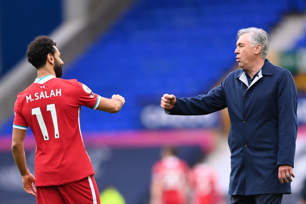 Liverpool's Egyptian midfielder Mohamed Salah (L) and Everton's Italian head coach Carlo Ancelotti react at the final whistle during the English Premier League football match between Everton and Liverpool at Goodison Park in Liverpool, north west England 