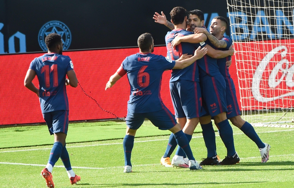 Atletico Madrid's Uruguayan forward Luis Suarez (C) celebrates with teammates after scoring a goal during the Spanish League football match between Celta Vigo and Atletico Madrid at the Balaidos stadium in Vigo on October 17, 2020. / AFP / MIGUEL RIOPA
