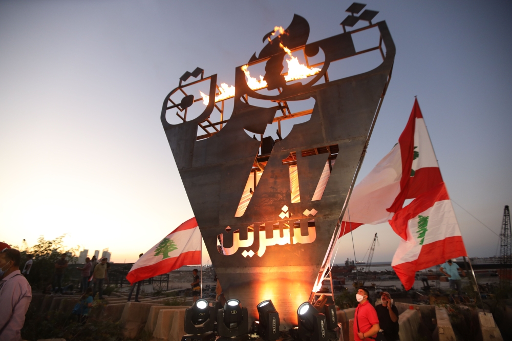 Lebanese protesters stand beneath the 