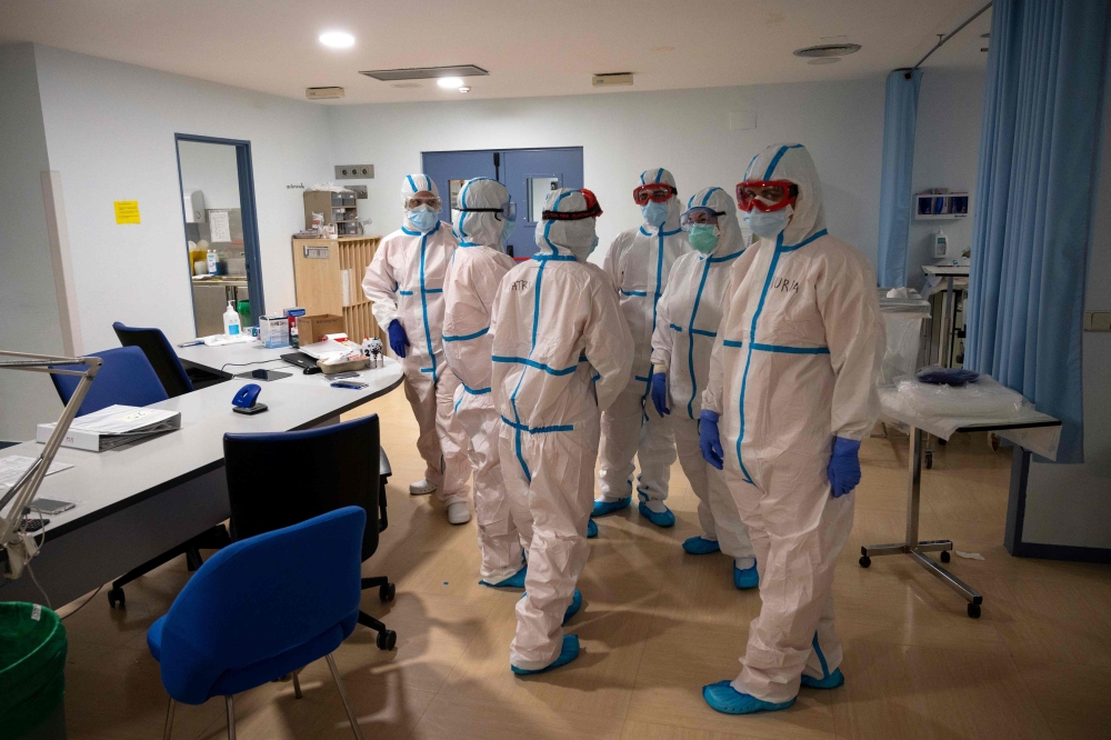 Healthcare workers chat at the Intensive Care Unit (ICU) of the Severo Ochoa University Hospital in Leganes on October 16, 2020. At Severo Ochoa hospital in a Madrid suburb badly-hit during the pandemic's first wave, the intensive care unit is once again 