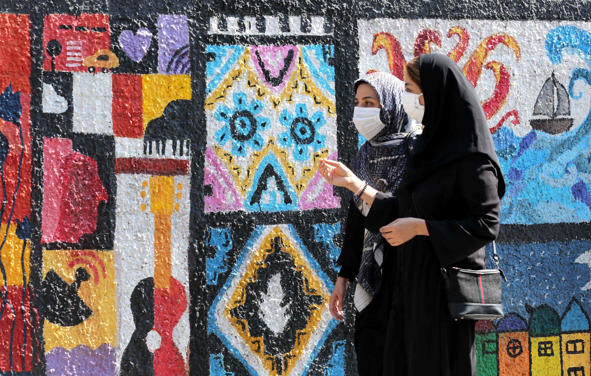 Iranian women wear face masks as a COVID-19 coronavirus pandemic precaution, in Iran's capital Tehran on October 14, 2020. / AFP / ATTA KENARE
