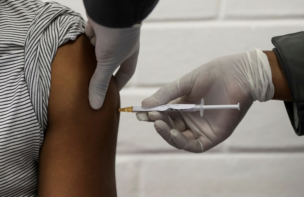 FILE PHOTO: A volunteer receives an injection from a medical worker during the country's first human clinical trial for a potential vaccine against the novel coronavirus, at the Baragwanath hospital in Soweto, South Africa, June 24, 2020. REUTERS/Siphiwe 