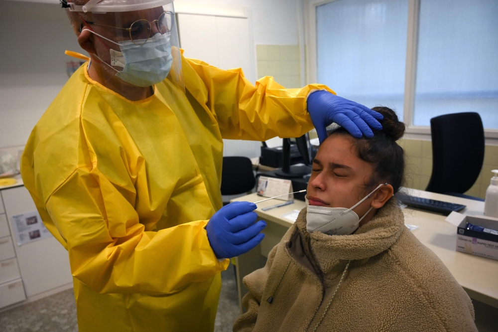 A healthcare worker takes a swap from a patient to run a COVID-19 Rapid Test at the CAP Manso primary care centre in Barcelona on October 21, 2020. AFP / LLUIS GENE