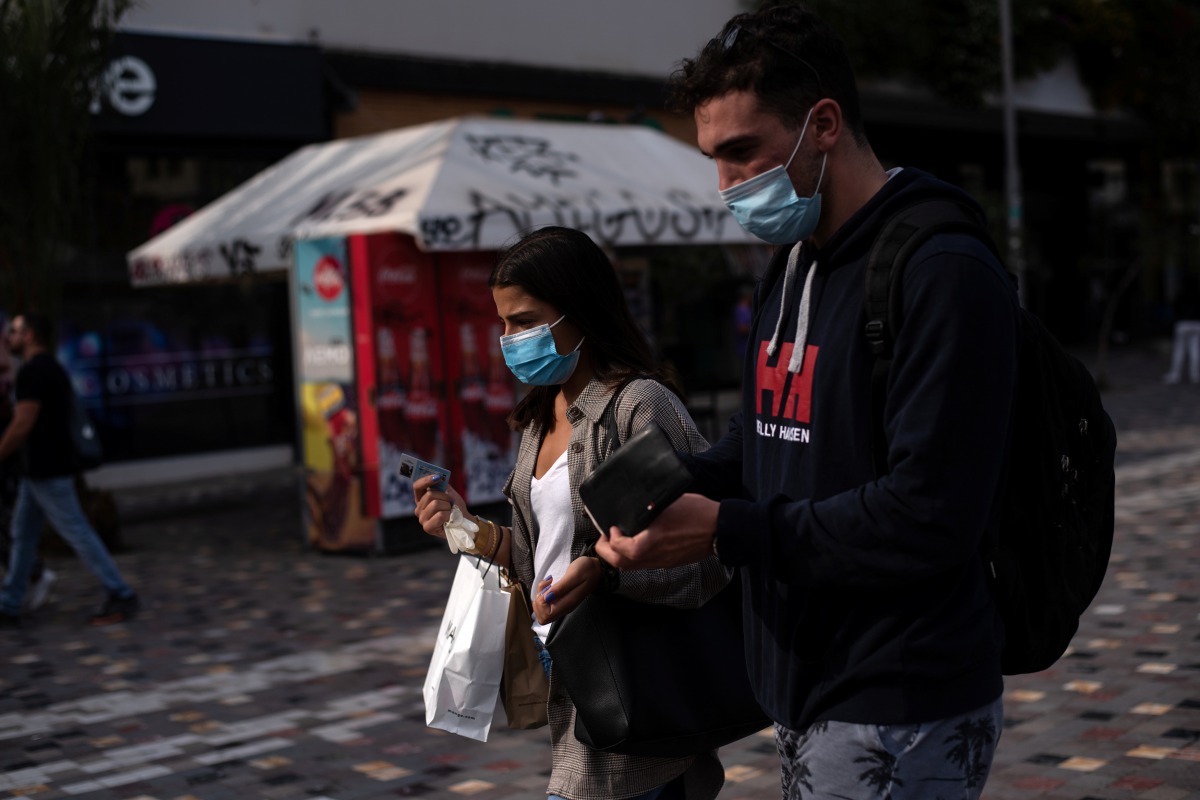 People wearing protective face masks make their way in Monastiraki square, amid the spread of the coronavirus disease (COVID-19), in Athens, Greece, October 22, 2020. REUTERS/Louiza Vradi 
