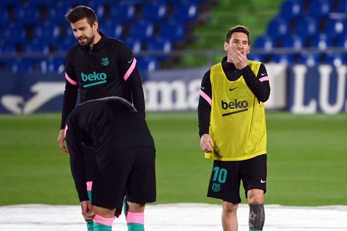 Barcelona's Spanish defender Gerard Pique (L) and Barcelona's Argentine forward Lionel Messi warm up before the Spanish League football match between Getafe and Barcelona at the Coliseum Alfonso Perez stadium in Getafe, south of Madrid, on October 17, 202