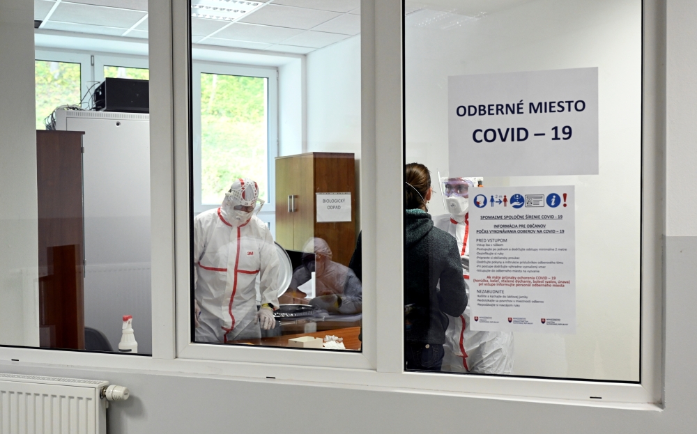 A healthcare worker collects a swab sample from a person at a COVID-19 testing site at the municipal office as the spread of the coronavirus disease (COVID-19) continues, in Oravsky Podzamok, Slovakia October 23, 2020. REUTERS/Radovan Stoklasa