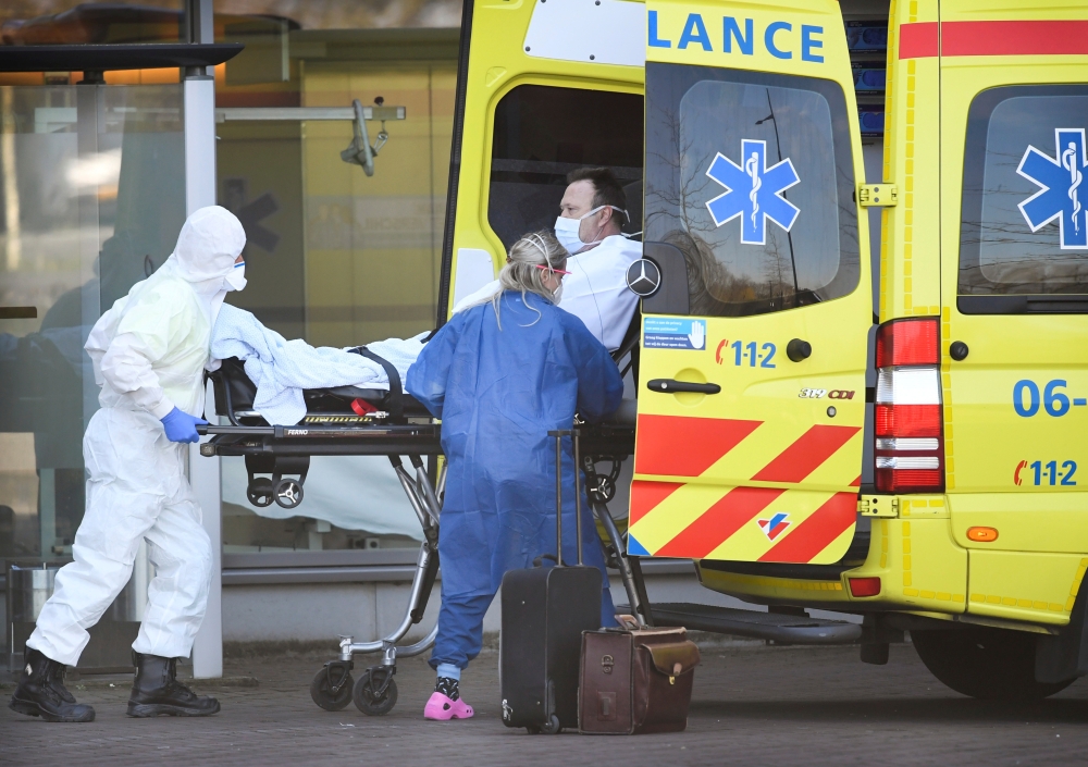 Dutch health workers leave with a patient at Bernhoven hospital, as the spread of coronavirus disease (COVID-19) continues, in Uden, Netherlands, March 25, 2020. REUTERS/Piroschka van de Wouw/File Photo