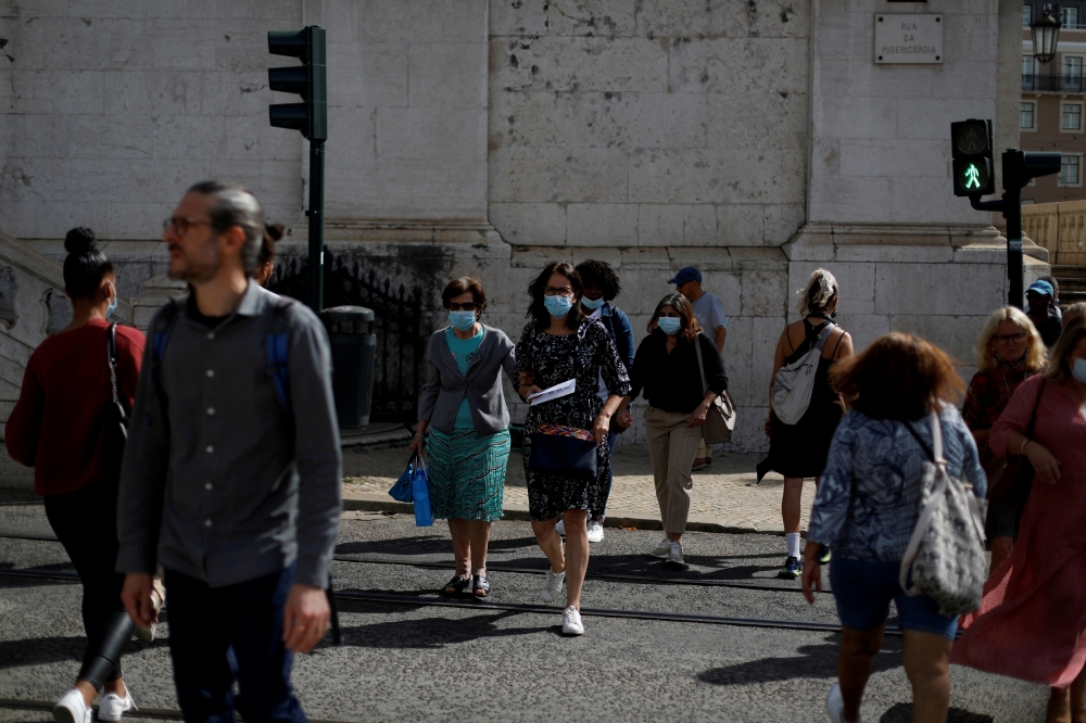 People cross a street at a traffic light during the coronavirus disease (COVID-19) outbreak, in downtown Lisbon, Portugal October 9, 2020. REUTERS/Rafael Marchante/File Photo/File Photo