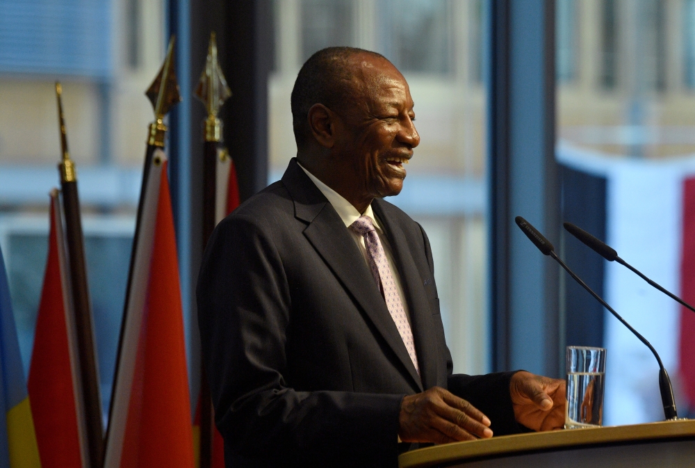 FILE PHOTO: Guinea's President Alpha Conde laughs as he addresses a conference in Berlin, Germany November 19, 2019. John MacDougall/Pool via REUTERS