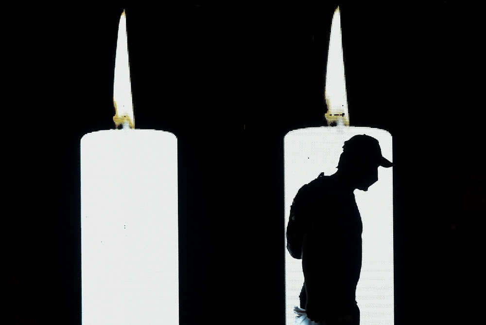 In this file photo taken on August 06, 2020 A man walks in front of a screen projecting candles in tribute to the dead by COVID-19 during the 482th anniversary of the city of Bogota. Colombia's Ministry of Health reported that the country surpassed on Oct