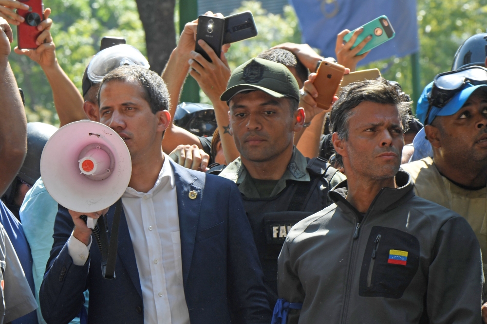 Venezuelan opposition leader and self-proclaimed acting president Juan Guaido (L) speaks to supporters next to high-profile opposition politician Leopoldo Lopez (R),  AFP / Federico PARRA