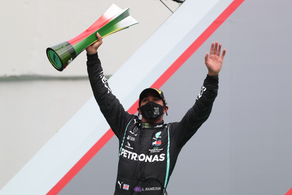 Mercedes' Lewis Hamilton celebrates winning the race on the podium. (REUTERS/Jose Sena Goulao)