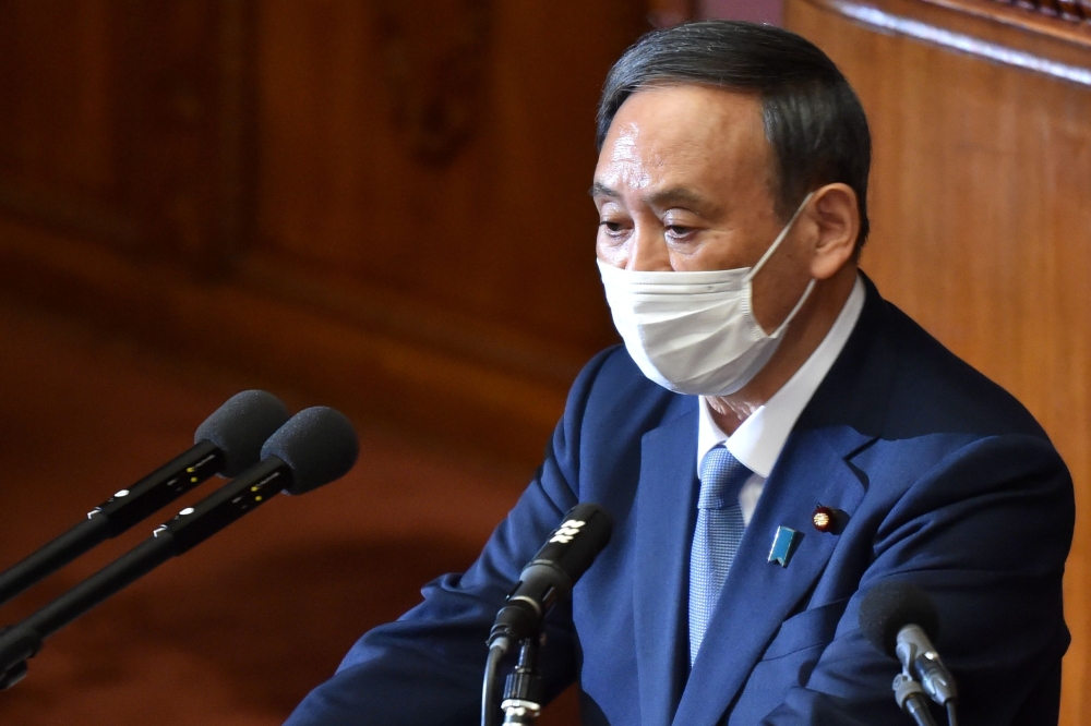Japan's Prime Minister Yoshihide Suga wearing a face mask, gives his policy speech during an extraordinary session at the lower house of parliament in Tokyo on October 26, 2020. Suga sets 2050 deadline for carbon neutrality. / AFP / Kazuhiro NOGI