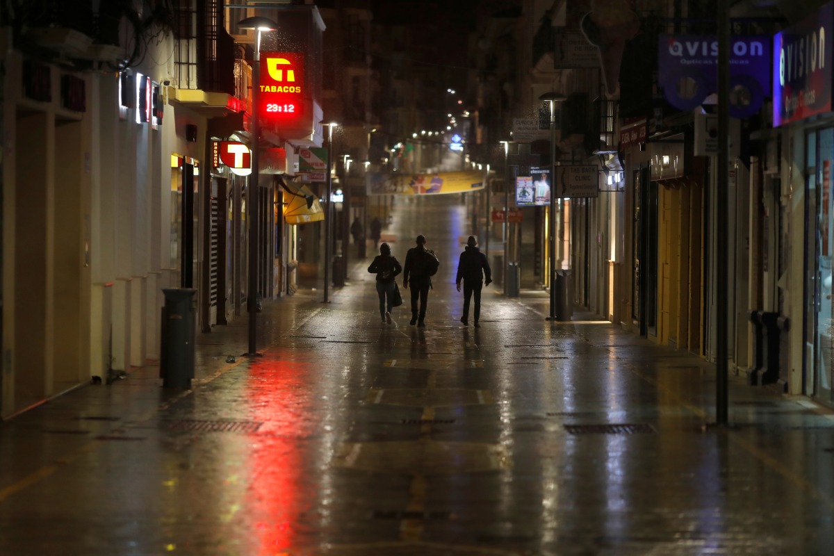 People walk along an empty street during the first day of the night-time curfew set as part of a state of emergency in an effort to control the outbreak of the coronavirus disease (COVID-19), in downtown Ronda, southern Spain late October 25, 2020. REUTER