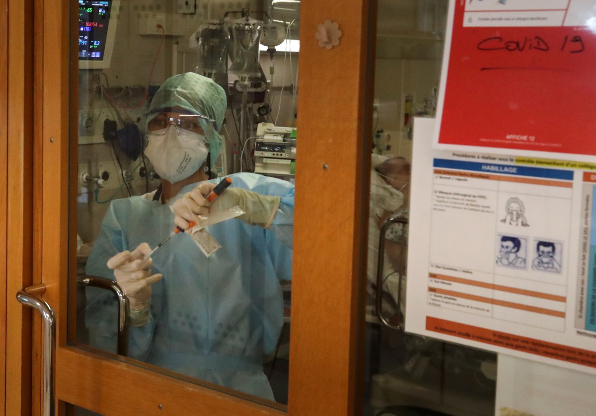 A member of the medical personnel at the CHU de Liege hospital looks through a door as they treat patients suffering from the coronavirus disease (COVID-19), in Liege, Belgium October 27, 2020. REUTERS/Yves Herman
