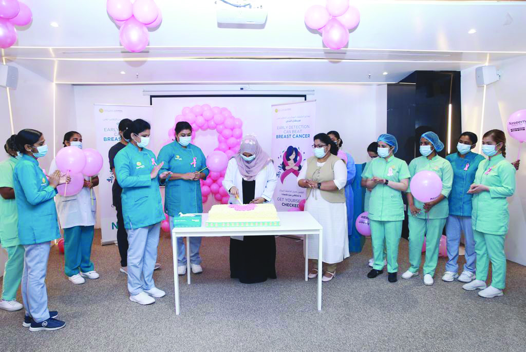 Employees of Naseem Medical Centre cutting a cake during the awareness event.