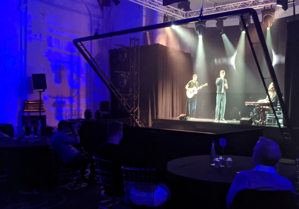 Singer-songwriter Dan Olsen and his guitarist use technology based on a Victorian optical illusion to demonstrate how Musion 3D's virtual concert system allows performers to connect with their fans in the locked-down world of the coronavirus pandemic, app