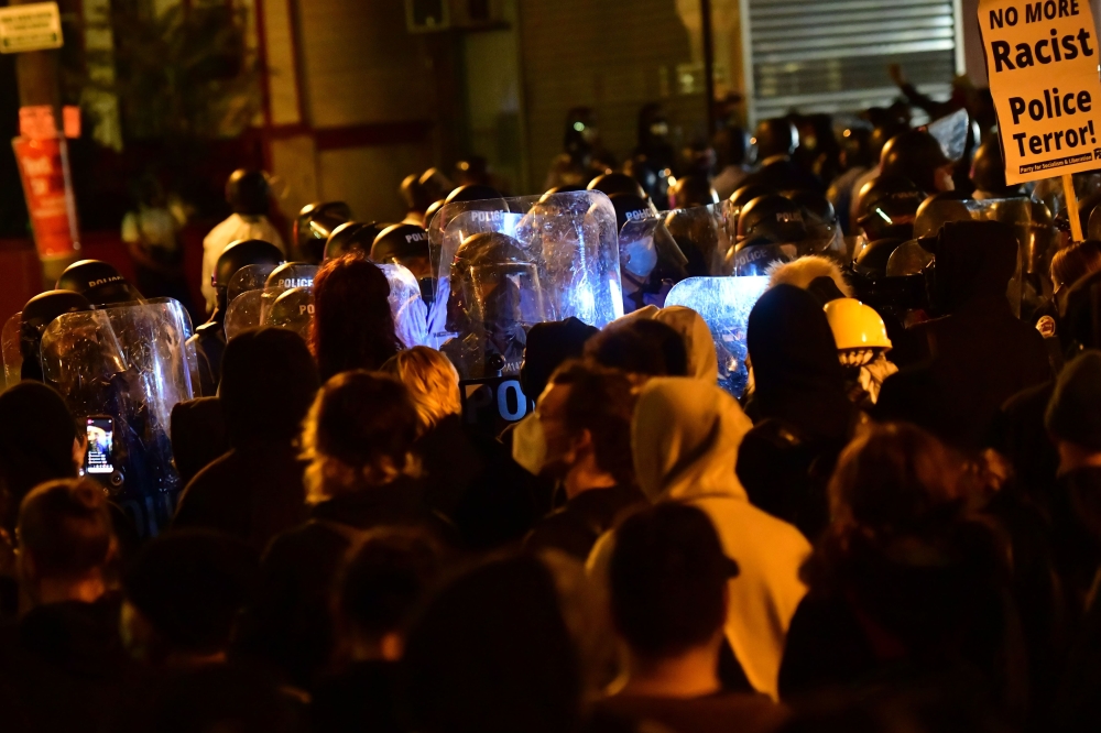 PHILADELPHIA, PA - OCTOBER 27: Police with shields form a line in front of demonstrators gathering in protest near the location where Walter Wallace, Jr. was killed by two police officers on October 27, 2020 in Philadelphia, Pennsylvania. Mark Makela/AFP 