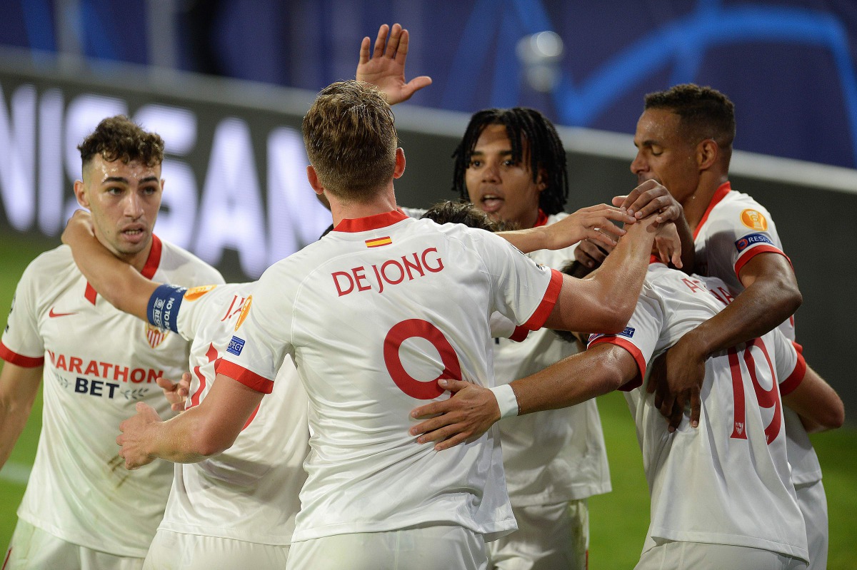 Sevilla's Dutch forward Luuk De Jong (C) celebrates with teammates after scoring a goal during the UEFA Champions League group E football match between Sevilla and Rennes at the Ramon Sanchez Pizjuan stadium in Sevilla on October 28, 2020. / AFP / CRISTIN