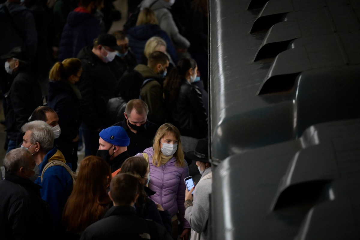 Commuters wearing face masks to protect against the coronavirus disease enter and leave a metro train in Moscow on October 29, 2020. / AFP / Natalia KOLESNIKOVA

