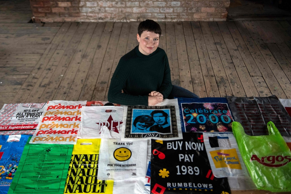 British artist Katrina Cobain, 24, poses for photographs with some of her collection of plastic bags from which she intends to start The Plastic Bag Museum in Glasgow on October 28, 2020.  AFP / ANDY BUCHANAN / TO GO WITH AFP STORY BY STUART GRAHAM