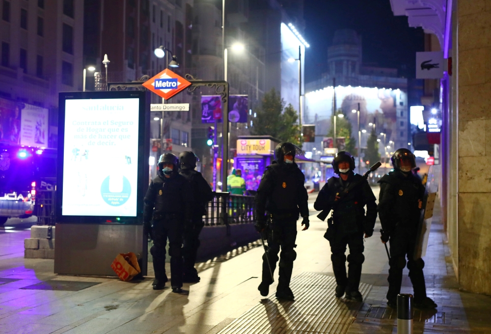 Police officers guard during a protest against the closure of bars and gyms, amidst the coronavirus disease (COVID-19) outbreak, in Madrid, Spain, November 1, 2020. REUTERS/Javier Barbancho