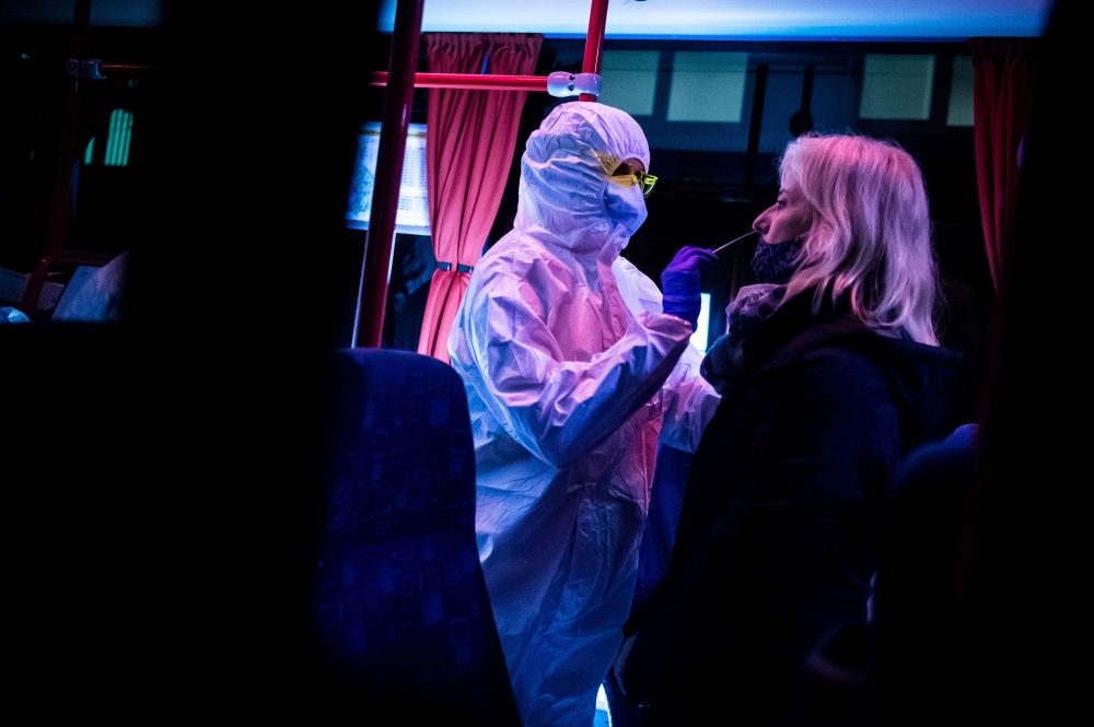A medic tests a woman for the novel coronavirus COVID-19 during nationwide testing in Bratislava, Slovakia on October 31, 2020. / AFP / VLADIMIR SIMICEK