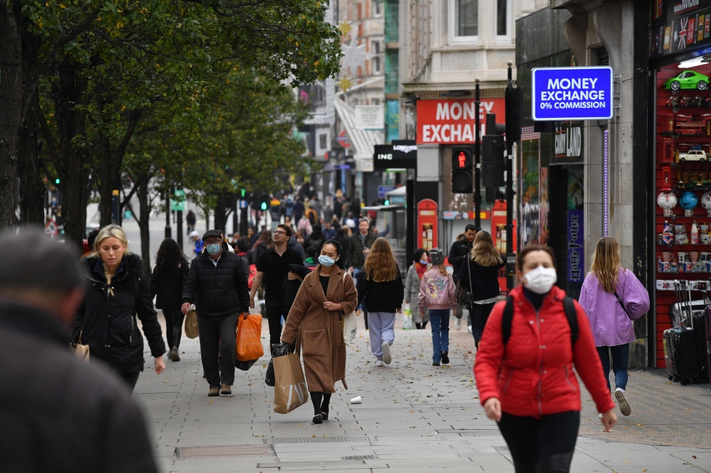 Pedestrians, some wearing masks because of the coronavirus pandemic, walk in the street in central London on November 1, 2020 as England prepares to enter into a second lockdown in an effort to stem soaring infections. / AFP / JUSTIN TALLIS