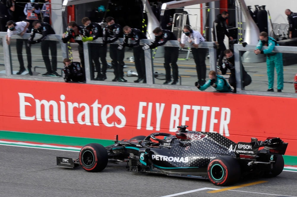 Mercedes' British driver Lewis Hamilton celebrates with his team after crossing the finish line to win the Formula One Emilia Romagna Grand Prix at the Autodromo Internazionale Enzo e Dino Ferrari race track in Imola, Italy, on November 1, 2020. / AFP / L