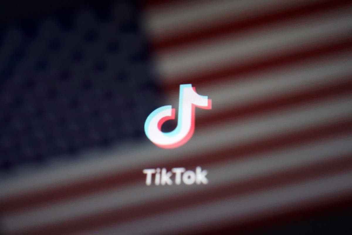 FILE PHOTO: A reflection of the U.S. flag is seen on the sign of the TikTok app in this illustration picture taken September 19, 2020. REUTERS/Florence Lo/File Photo
