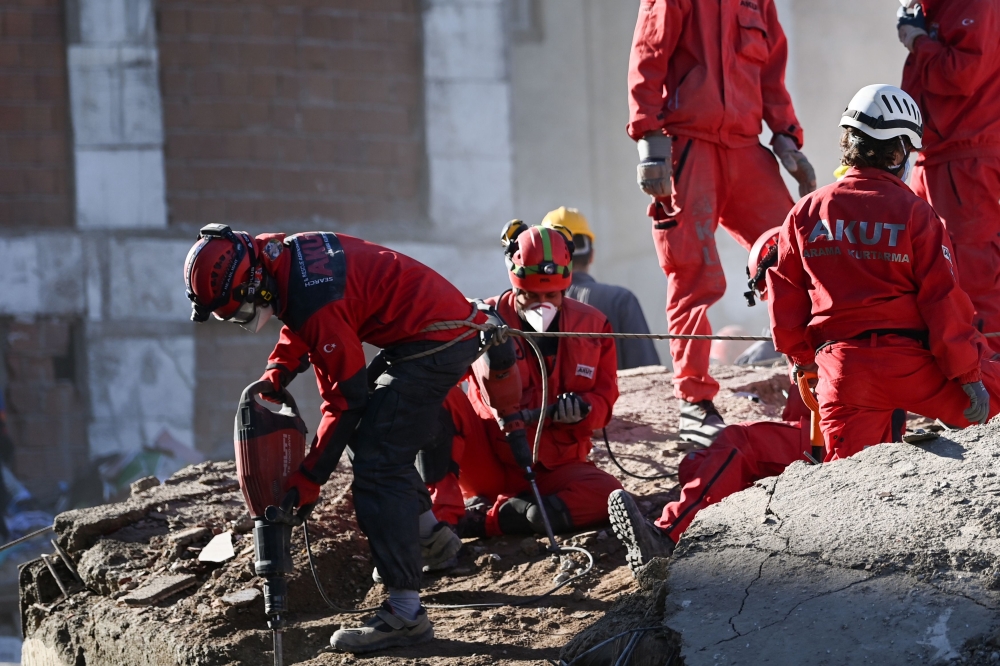 Rescue workers remove rubble during the ongoing search operation at the site of a collapsed building as they look for survivors and victims in the city of Izmir on November 2, 2020, after a powerful earthquake struck Turkey's western coast and parts of Gr